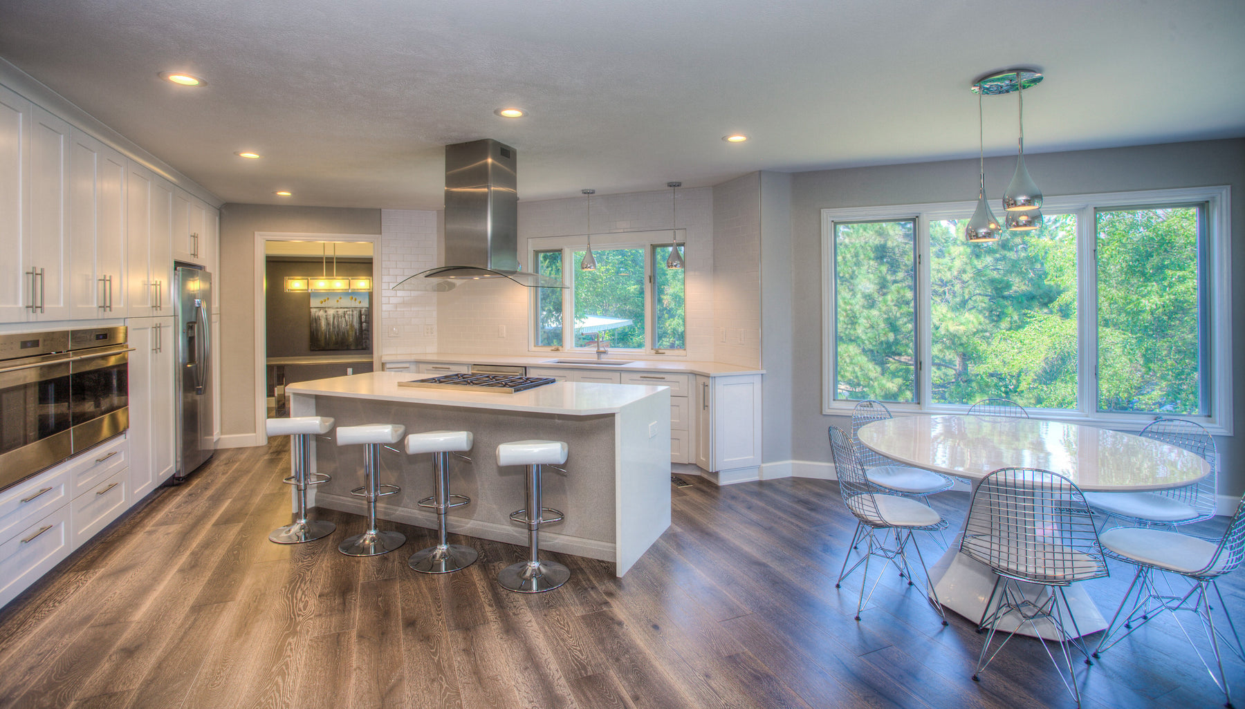 Light-filled kitchen with white cabinetry, a generous island and wood-look flooring